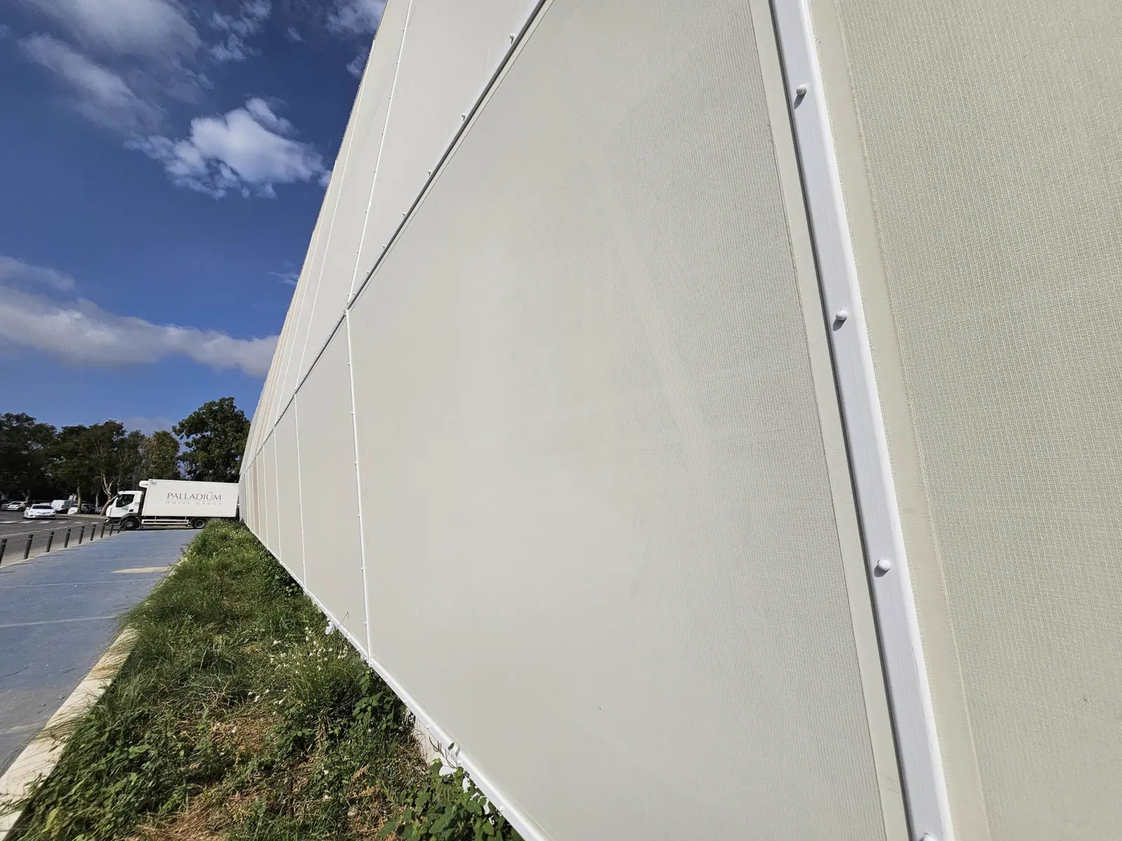 Arista de una fachada textil tensada vista desde la acera