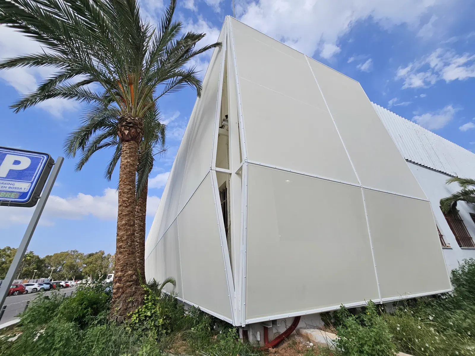 Esquina de una fachada textil con una palmera delante