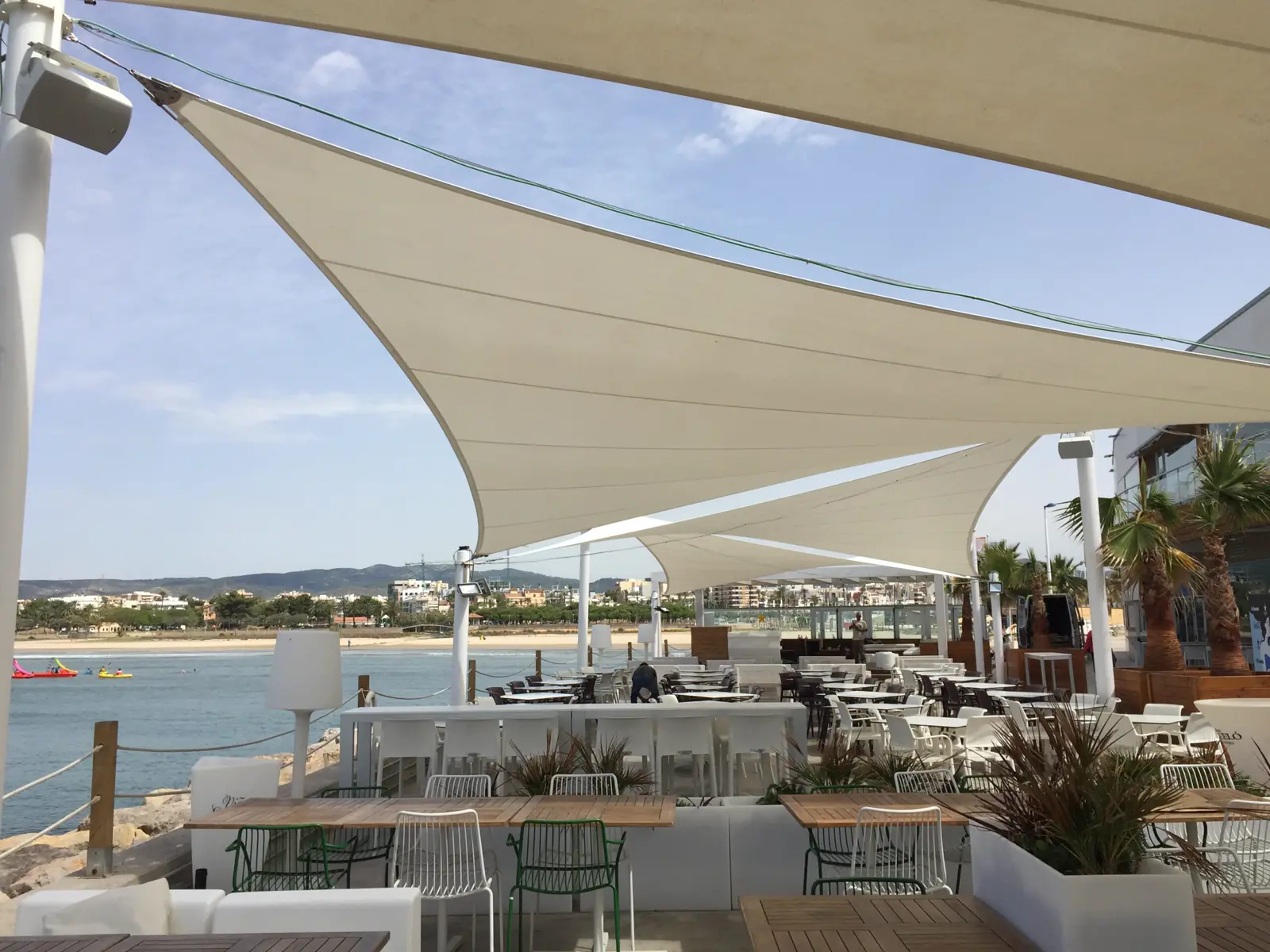 Velas tensadas sobre la terraza de un chiringuito frente al mar