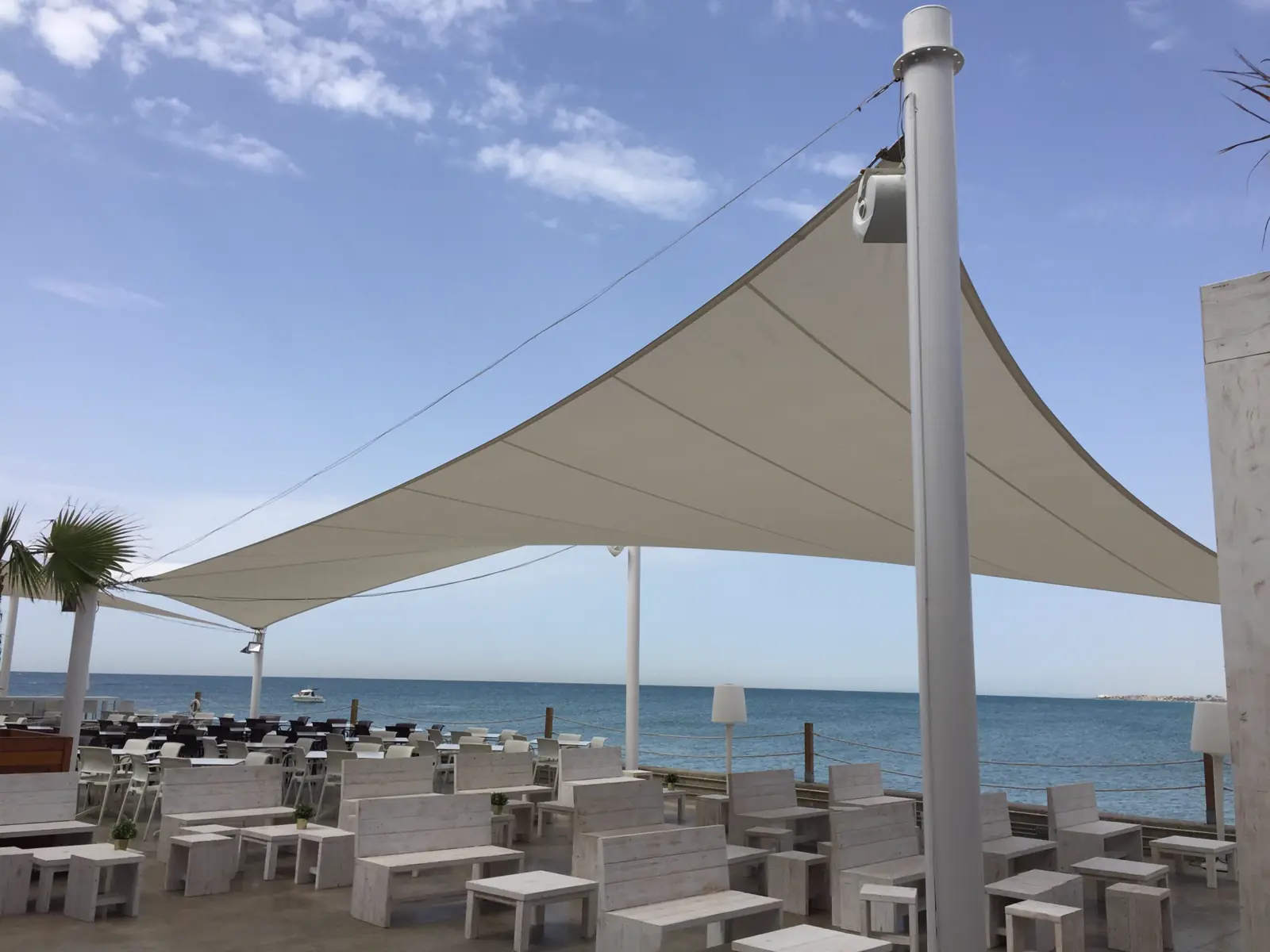 Velas tensadas sobre una terraza con vistas al mar