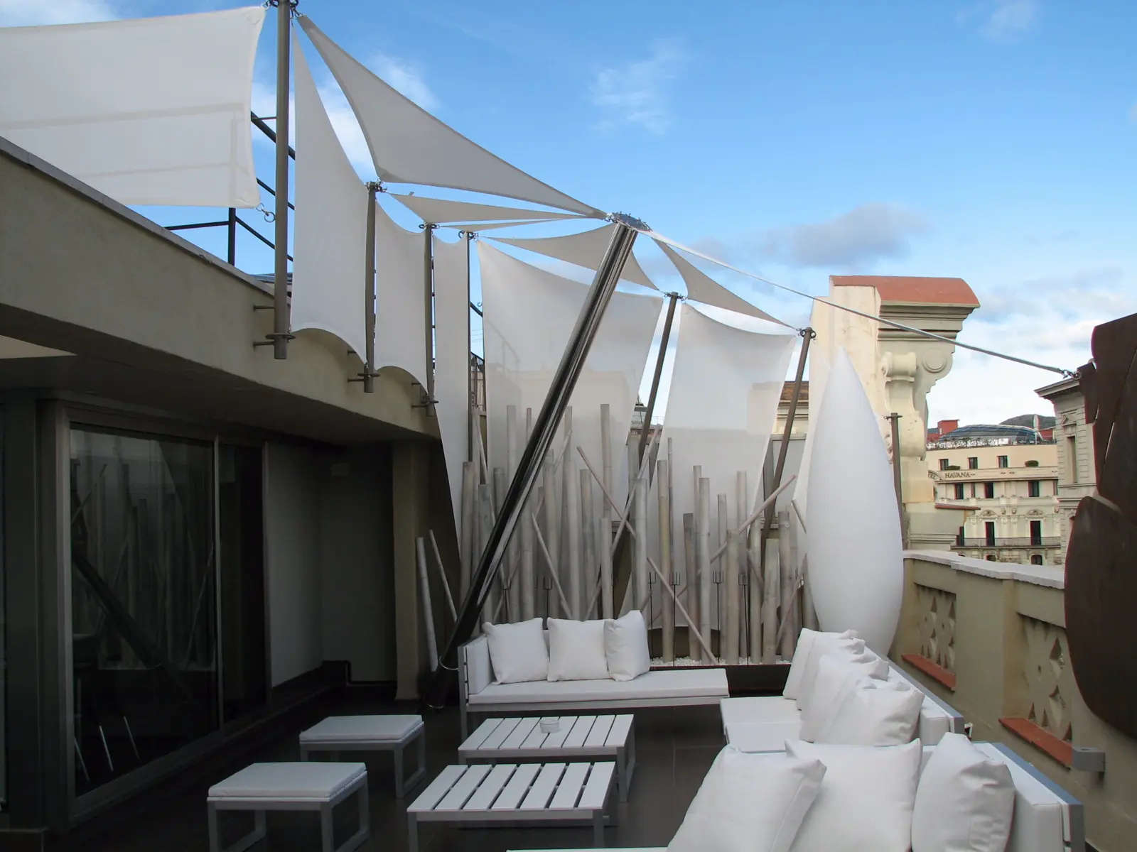 Vela tensada sobre una terraza con sofás blancos