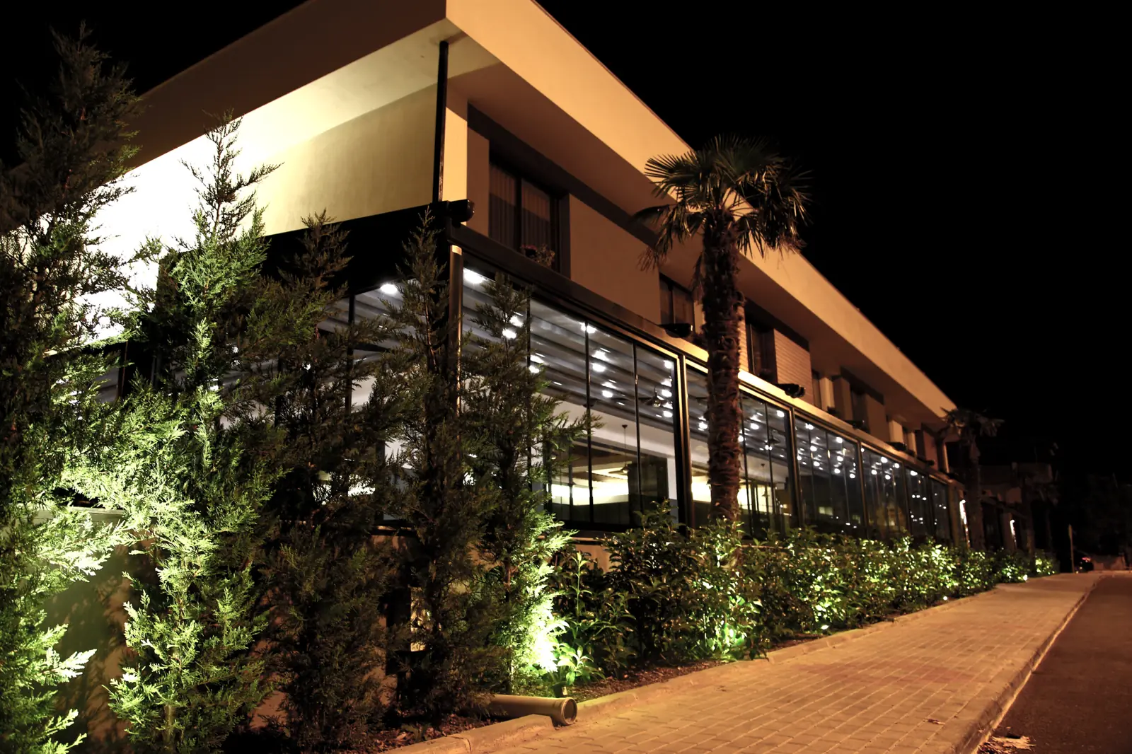 Terraza de restaurante de noche bajo una pérgola iluminada