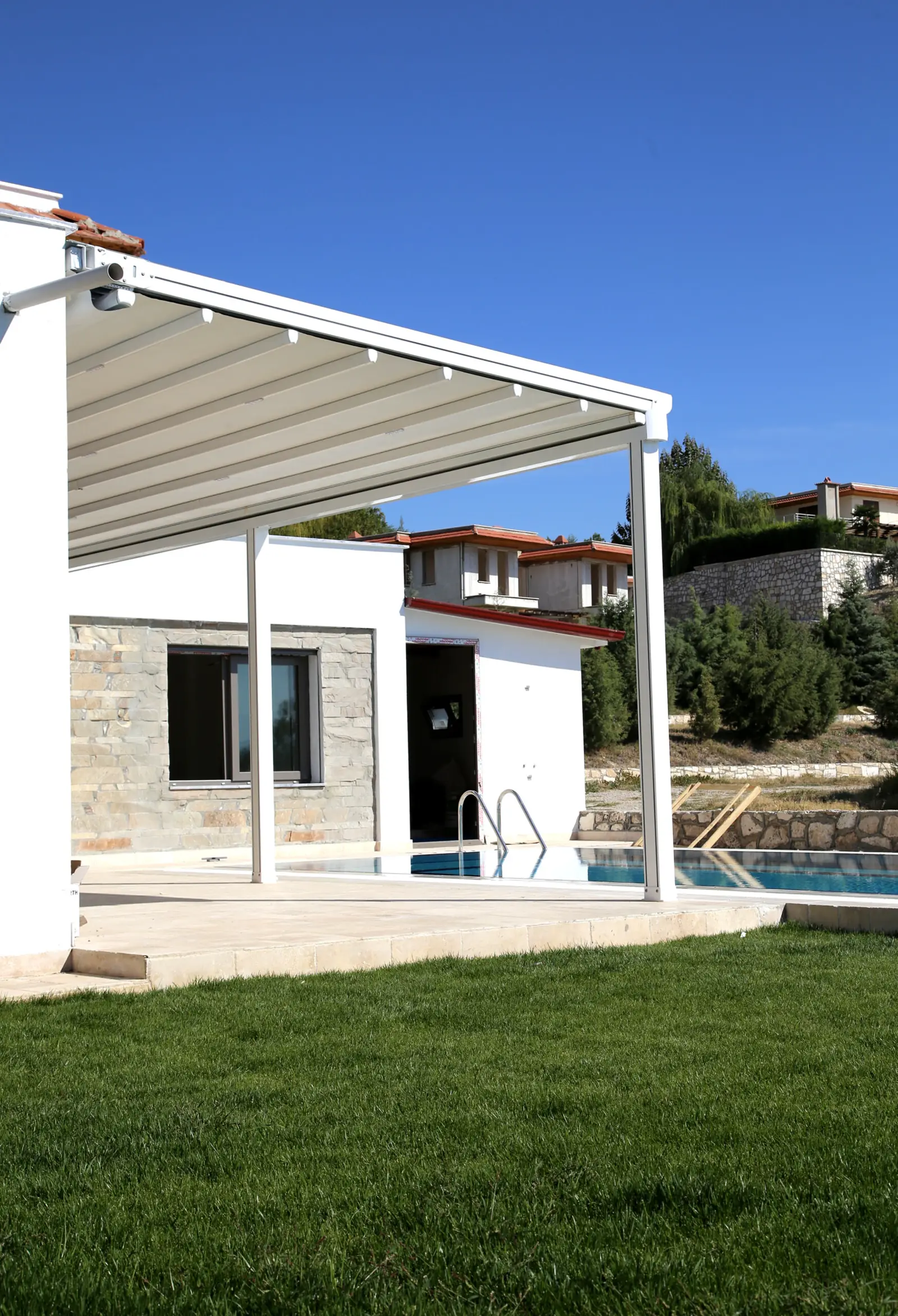 Pérgola blanca adosada a una casa con piscina
