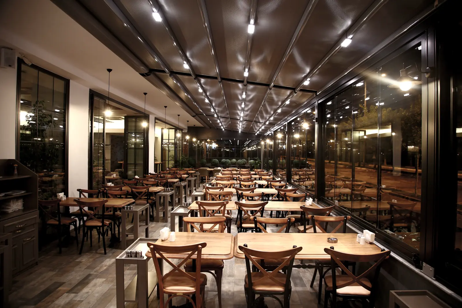Comedor bajo una pérgola con luces de noche