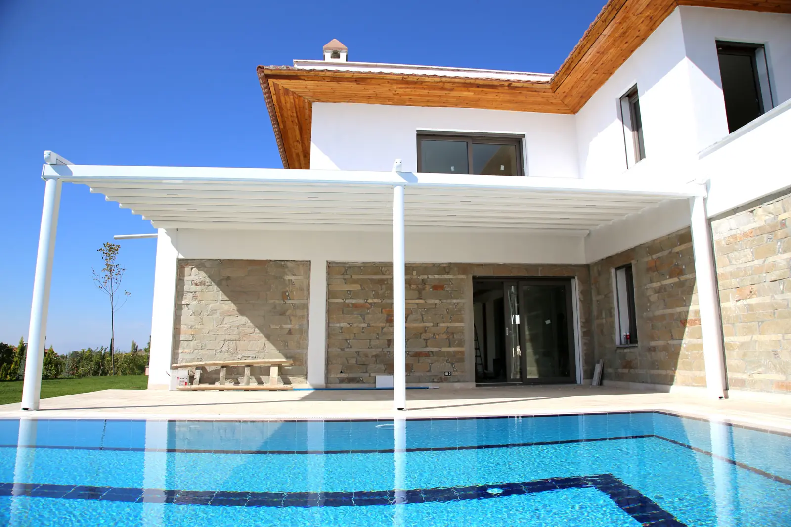 Pérgola blanca junto a la piscina de una vivienda