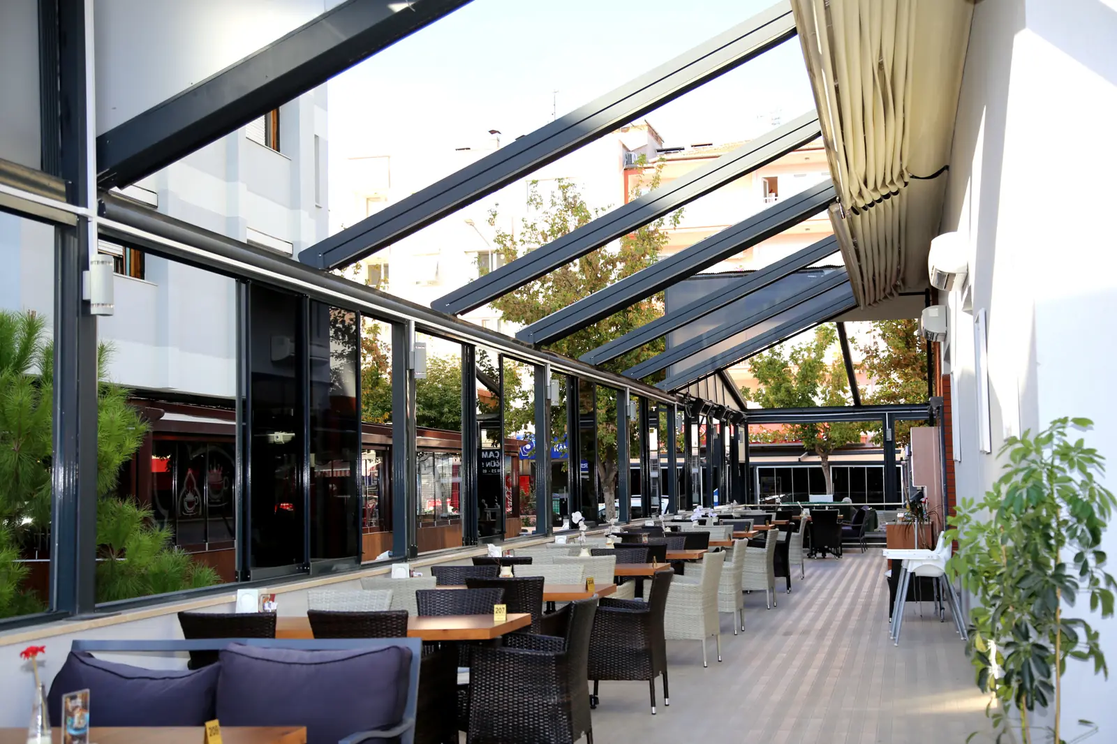 Comedor de restaurante bajo una pérgola acristalada