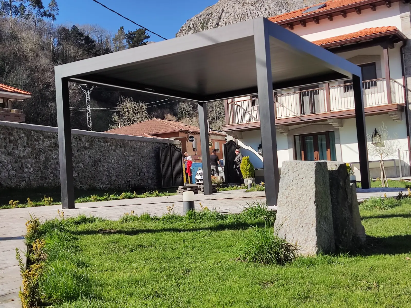 Pérgola bioclimática sobre el césped de un jardín