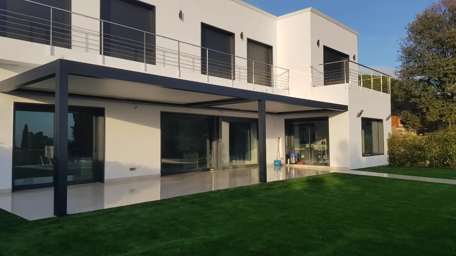 Pérgola bioclimática gris en el porche de una casa