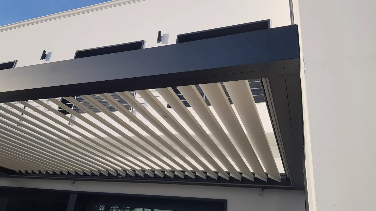 Detalle de las lamas blancas de una pérgola bioclimática