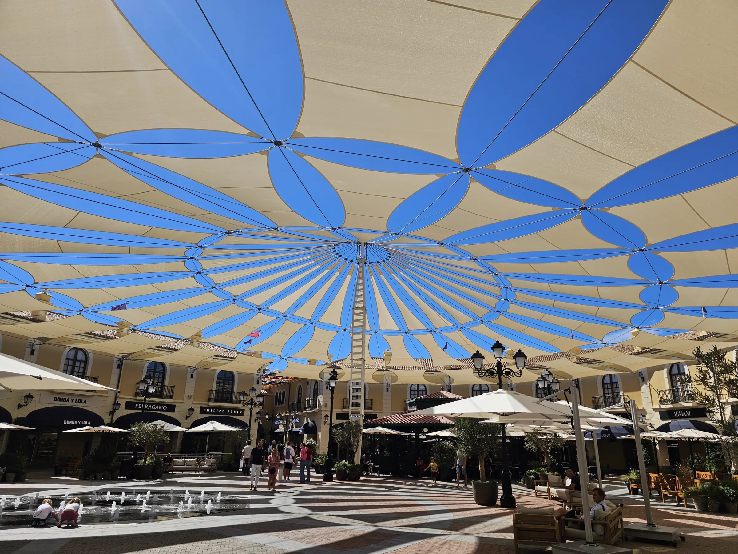 Gran cubierta textil azul y blanca sobre una plaza comercial