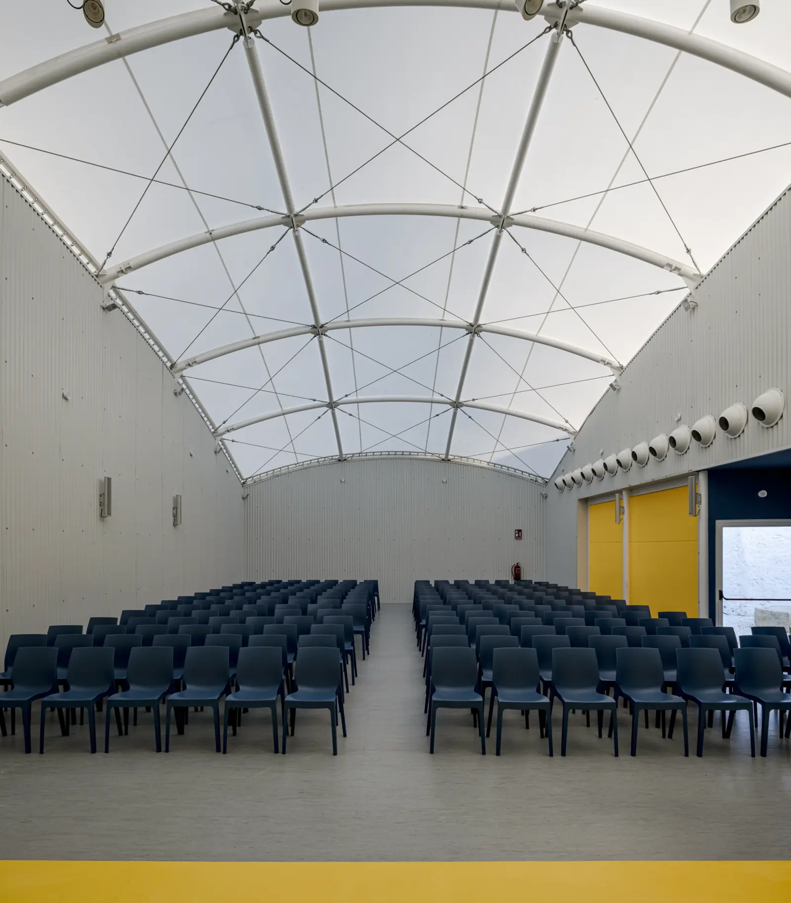 Sala interior cubierta por una gran membrana textil blanca