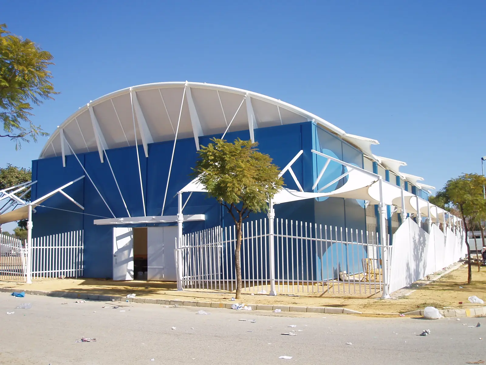 Marquesina textil blanca junto a un edificio azul